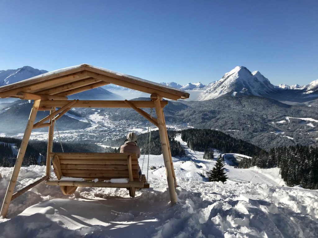 Die Schaukel steht im Schnee mit Blick auf die Berge. Markant ist die Spitze der hohen Munde.